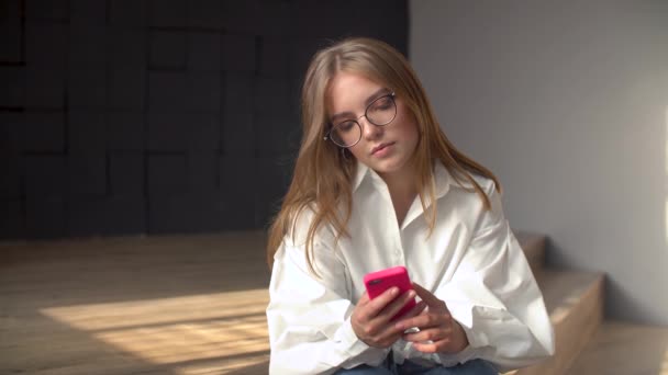 Jeune femme utilisant un smartphone dans un salon — Video