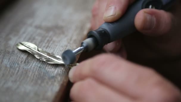 Goldschmied poliert Bronze Anhänger mit Schleifer — Stockvideo