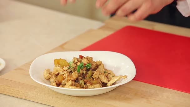 Koch legt geschnittene Petersilie und Sonnenblumenkerne zu heißem Hühnersalat — Stockvideo