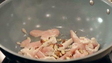 Ayçiçeği tohum koyarak ve ezilmiş badem içine sıcak tava tavuk fileto ile aşçı olduğunu