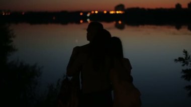 Arka planda suda yansıyan Cityscape ile aile Silhouettes