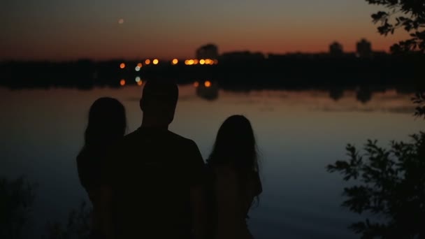 Famille couples silhouettes avec vacances paysage urbain reflété dans l'eau en arrière-plan — Video