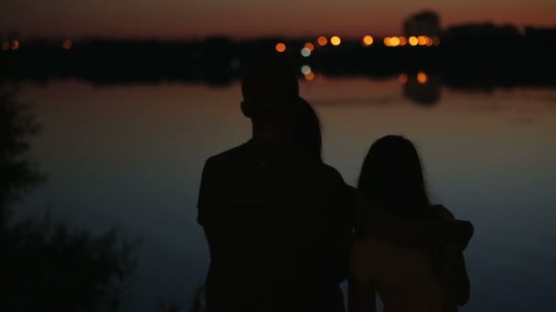 Silhouettes familiales avec paysage urbain reflété dans l'eau en arrière-plan — Video