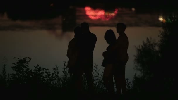 Famille couples silhouettes avec vacances paysage urbain reflété dans l'eau en arrière-plan — Video