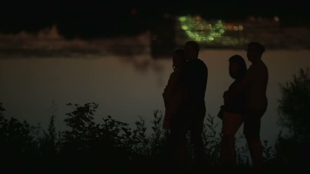 Famille couples silhouettes avec vacances paysage urbain reflété dans l'eau en arrière-plan — Video