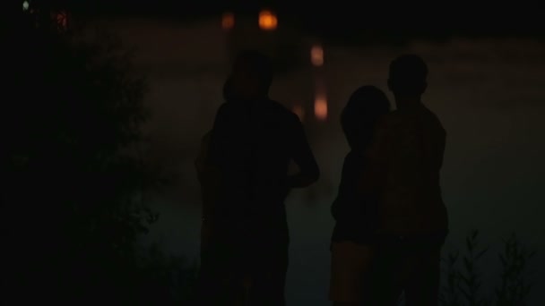 Familienpärchen Silhouetten mit Urlaub Stadtbild spiegelt sich im Wasser im Hintergrund — Stockvideo