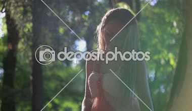 Güneşli bir yaz günü banktaoturuyor pembe elbiseli kız