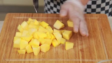 Chef is slicing fresh pumpkin as ingredient for chicken stew dish