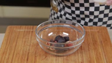 Şef salatanın malzemesi olarak taze inciri bir kasede tatlandırıyor.