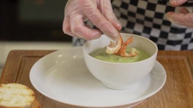 Şef karides ve tostlu brokoli kremalı çorba servis ediyor.