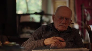 Kronik engelli yaşlı yetişkin tekerlekli sandalyede oturan bilgisayarla çalışıyor.