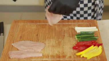 Profesyonel Heff fırında pişirmek için tavuk fileto ve sebze hazırlıyor.