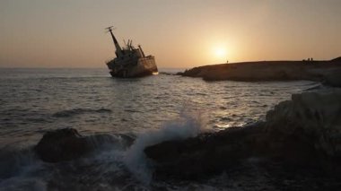 Paphos, Kıbrıs - 03.09.2025 - Gün batımında kıyı şeridi yakınlarındaki paslı eski gemi enkazı