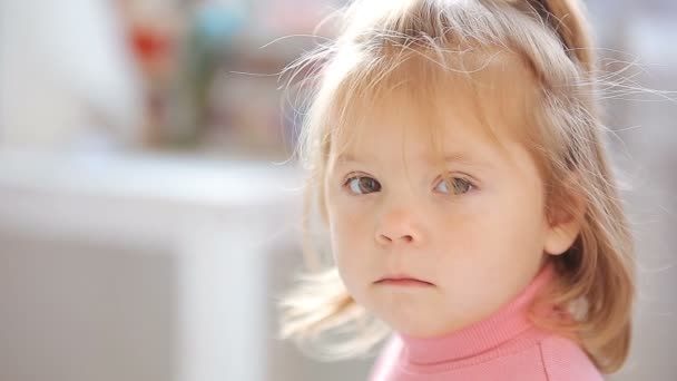 Blond aux yeux bleus petite fille à l'air ennuyée et sérieuse — Video