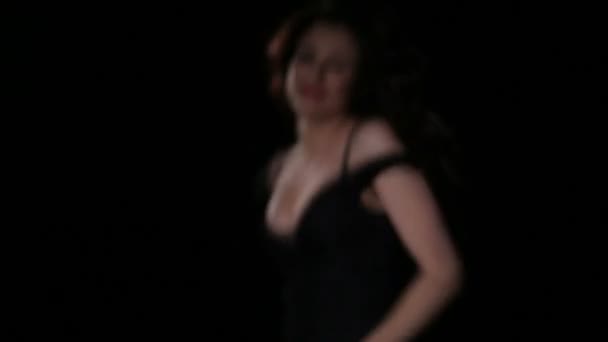 Junge Brünette im schwarzen Partykleid tanzt, lächelt, hat Spaß und flirtet — Stockvideo