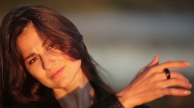 Genç bir esmer kadının yüzünde güneş ışınları gündoğumu sırasında zevk yakın çekim