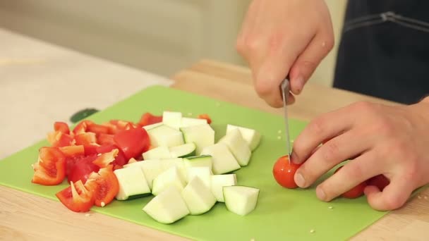 Cheff está cortando tomates cherry, calabacín y pimentón rojo — Vídeos de Stock