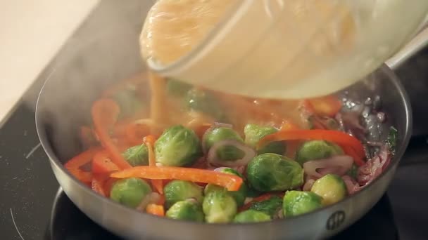 Омлет с красной паприкой, брюссельской капустой и луком, жарящимся на сковороде — стоковое видео