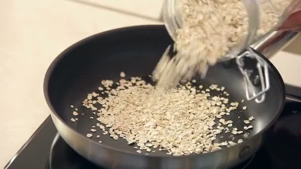 Chef está secando flocos de aveia em uma frigideira — Vídeo de Stock