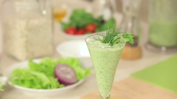 Chef décore un verre de Smoothies aux légumes verts avec des herbes et du piment rouge — Video