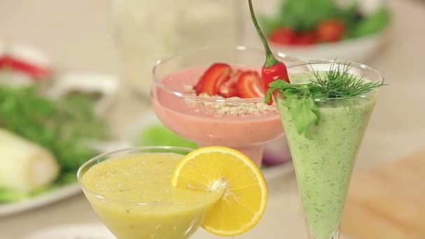 Presentatie van aardbei, groene groenten en citrusvruchten Smoothies ingericht in glazen — Stockvideo