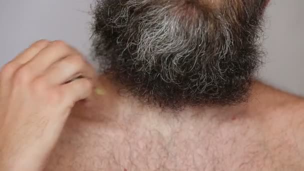 Hombre blanco cuidando de su exuberante barba y bigote — Vídeos de Stock