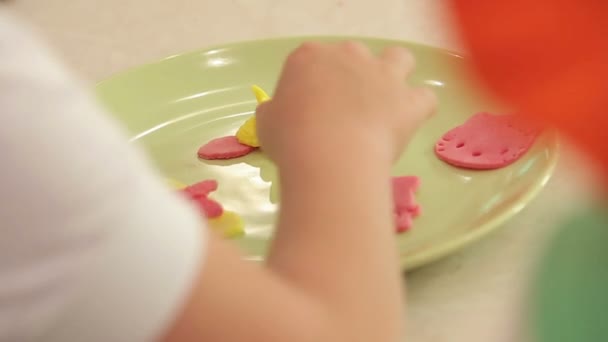 Close up de crianças mãos fazendo cookies coloridos — Vídeo de Stock