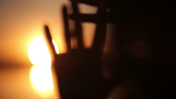 Silhouet van vrouwelijke handen spelen met zonnestralen tijdens zonsopgang. Lens Flare effecten — Stockvideo