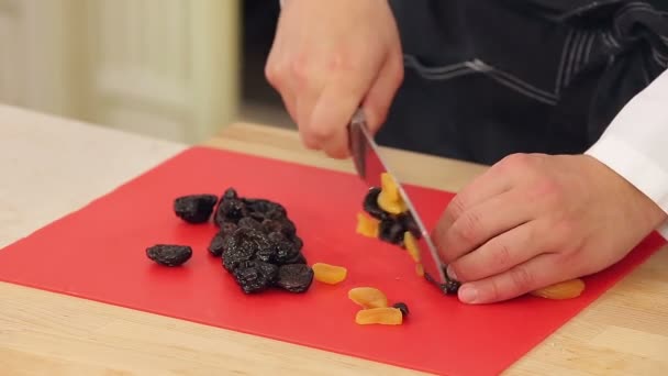 Kocken skär torkade aprikoser och plommon — Stockvideo