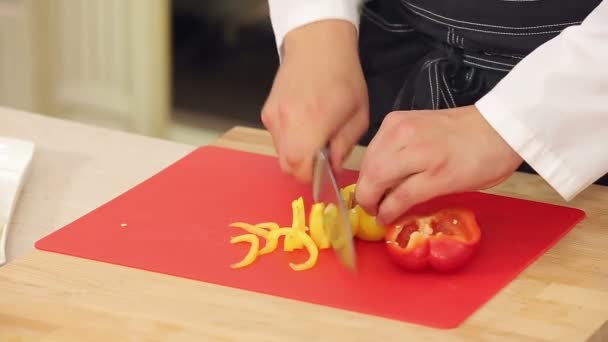 Chef está cortando páprica vermelha e amarela — Vídeo de Stock