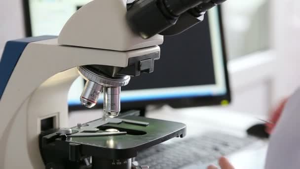 Лаборатория микробиологии работает с микроскопом — стоковое видео