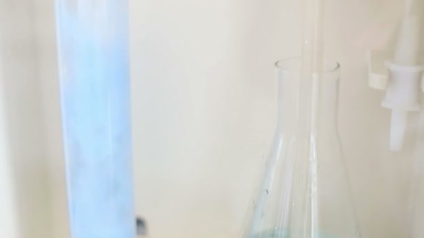 Glas in een chemisch laboratorium, gekleurde vloeistof tijdens de reactie — Stockvideo