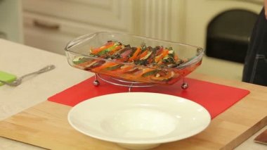 Şef taze pişmiş ratatouille bir plaka üzerinde hizmet vermektedir