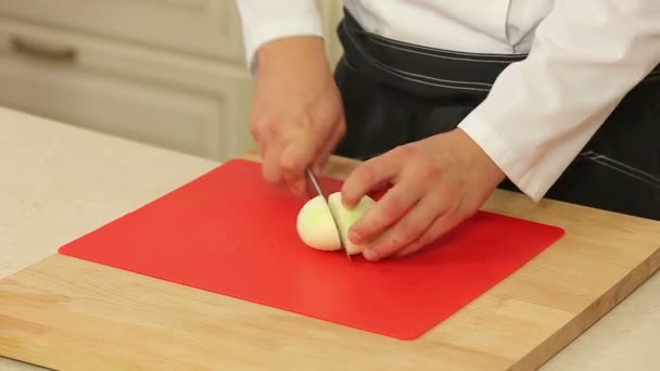 Chef cortando una cebolla con un cuchillo — Vídeos de Stock