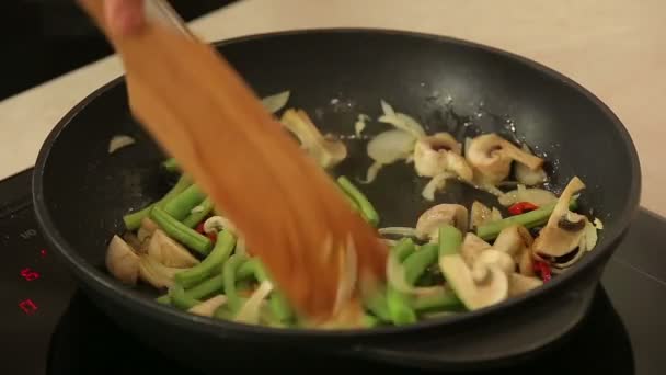 Шеф-повар жарит овощи на сковороде — стоковое видео