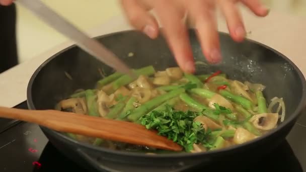 Szef kuchni jest smażenie warzywa na patelni — Wideo stockowe