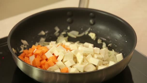 Σεφ stewing ψιλοκομμένα λαχανικά σε ένα τηγάνι — Αρχείο Βίντεο