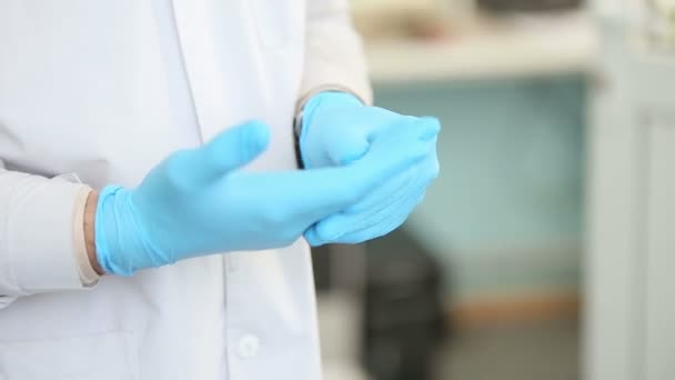 Arzt zieht medizinische Handschuhe an