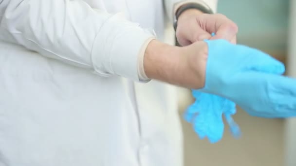 Doctor putting on medical gloves — Stock Video