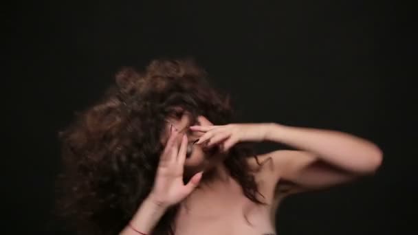 Молодая брюнетка с длинными темными вьющимися волосами танцует — стоковое видео