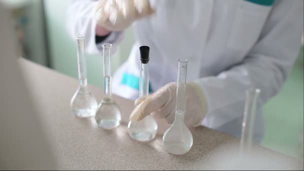 Onderzoeker werkt met vloeistoffen in chemisch laboratorium — Stockvideo