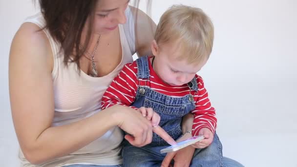 Jovem mãe e filho miúdo brincando com telefone celular — Vídeo de Stock