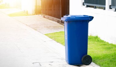 Mavi çöp tenekeleri yol kenarında..