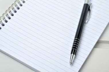ahşap masa üstünde kalem ile defter
