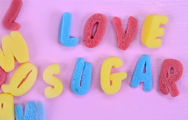 ピンクのテーブルの上の言葉愛の砂糖 — ストック写真