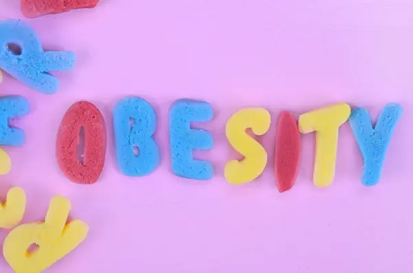 Obesity word on pink table — Stock Photo, Image