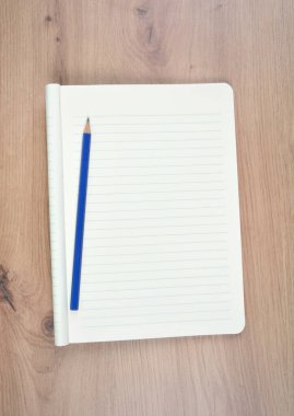 Ahşap bir masanın üzerinde boş bir defter.