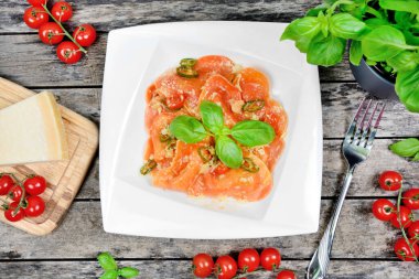 Kırmızı kalpli ravioli, vişneli domates, mozzarella, parmesan ve fesleğen. Üst görünüm