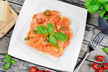 Kırmızı kalpli ravioli, kiraz domatesi, mozzarella, parmesan ve fesleğen.