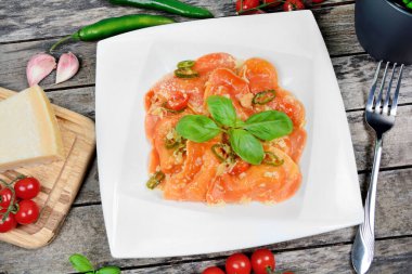 Tabağı kırmızı kalpli ravioli ile kapat kiraz domatesi, mozzarella, parmesan ve fesleğen.